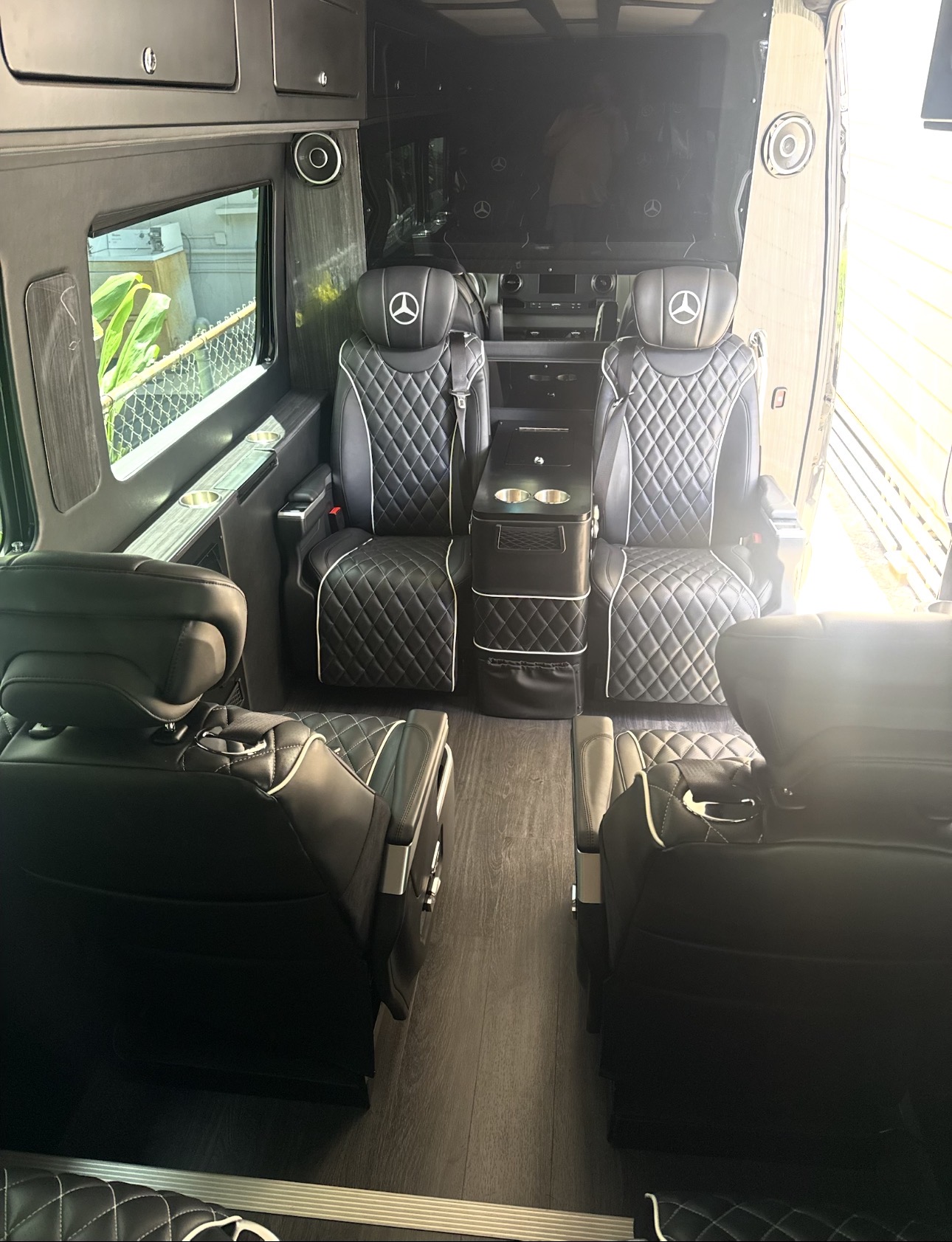 Diamond-stitched leather captain chairs inside the executive Mercedes Sprinter